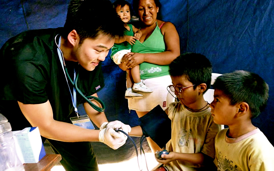 A doctor taking the blood pressure of small children