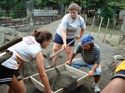 Volunteers dumping dirt in a box for plants