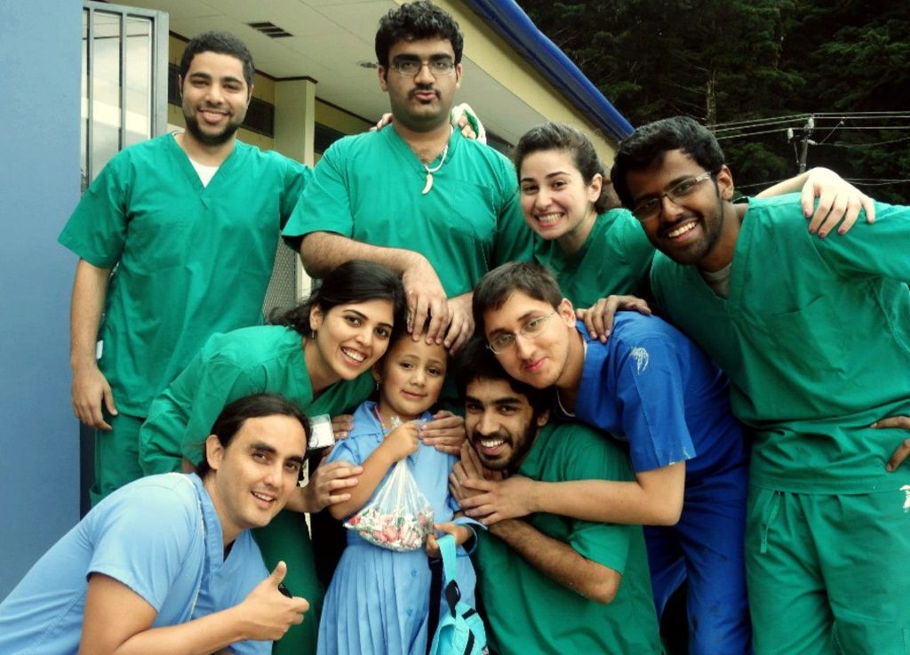 A group of doctors and nurses taking a group photo with a child