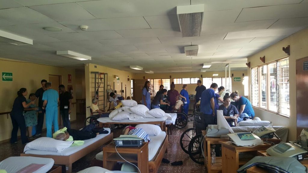 A hospital room with patients and doctors