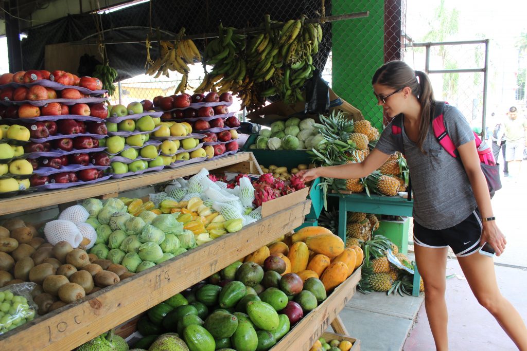 Women grabbing some fruit at a fruit stand