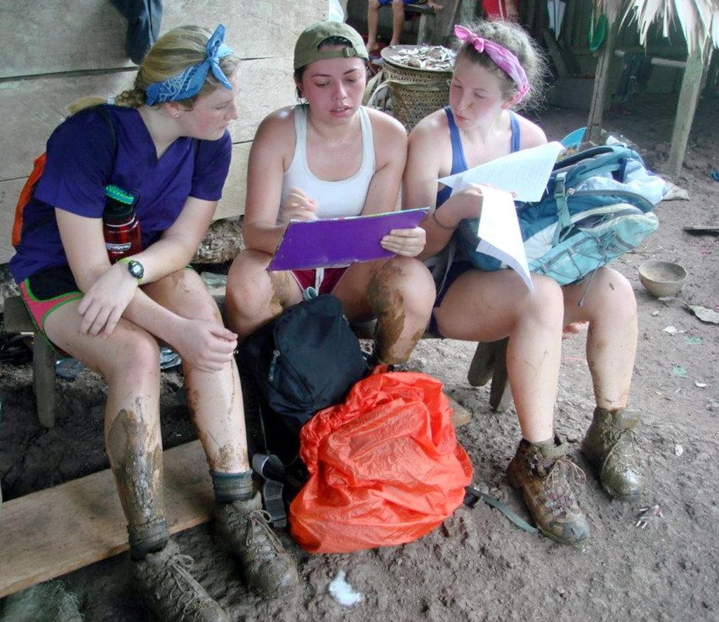 Three volunteers looking at notes after hike