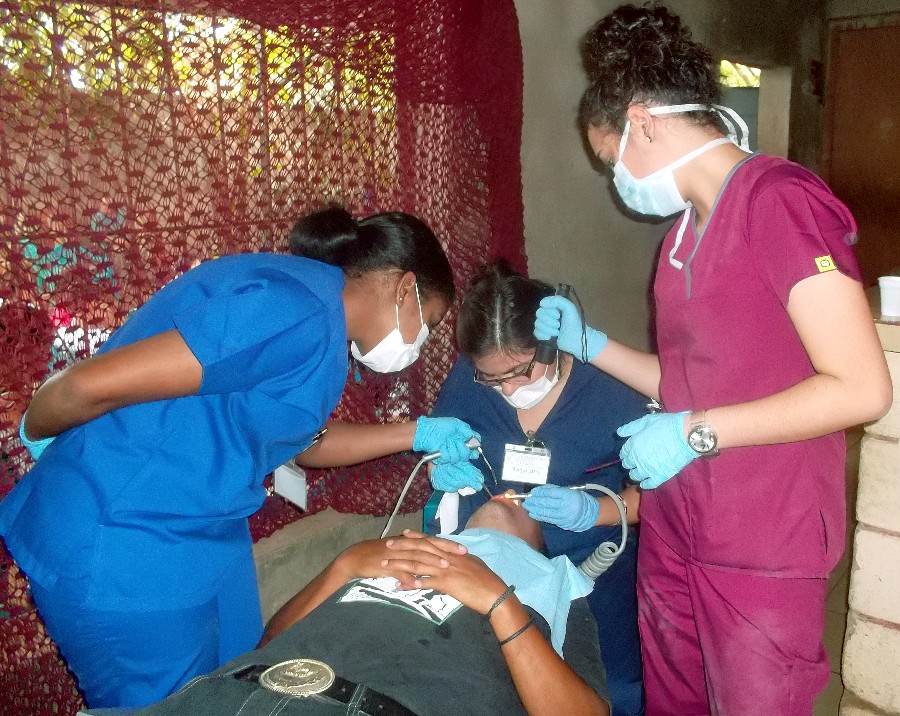 Volunteer dentists performing a procedure on a mans teeth