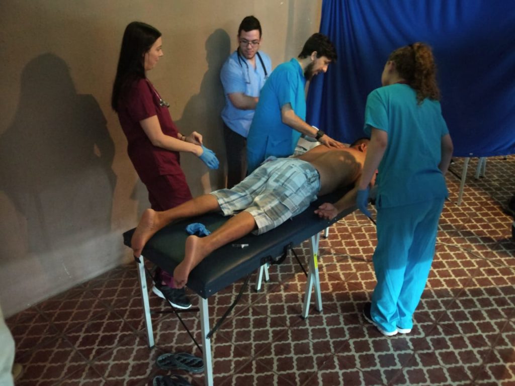 A physical therapist performing a procedure on a man laying on a table