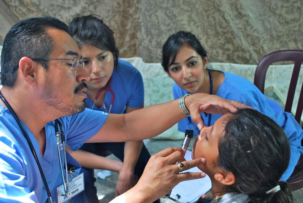 Doctor looking at a student with a light