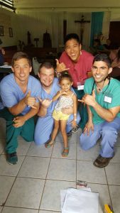 A group of doctors and a small child taking a photo for the camera