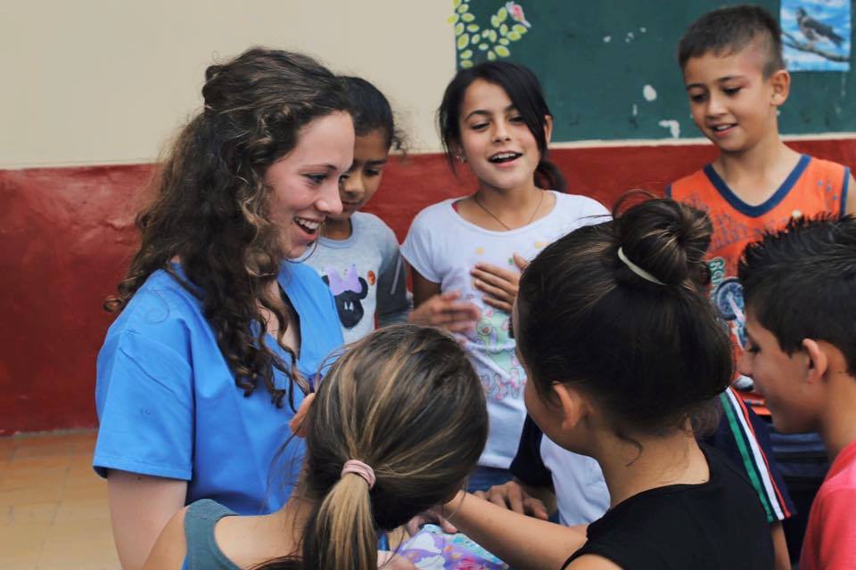 A volunteer smiling and teaching children
