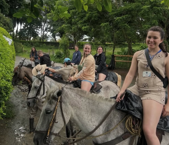 Volunteers riding horse and smiling for the camera