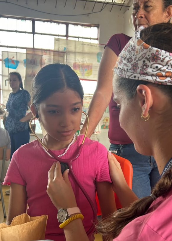 A nurse showing a child the sound of her own heart beat