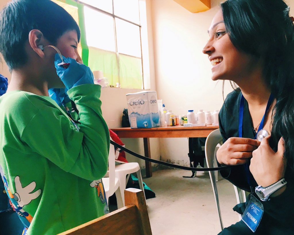 A nurse in Costa Rica showing a small child the sound of her own heart beat