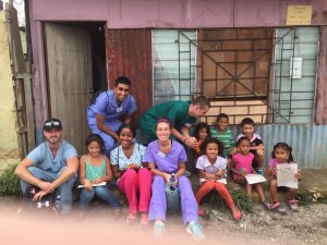 A group of doctors and nurses taking a photo with some small children