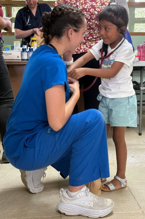 A nurse showing a child the sound of her heart beat