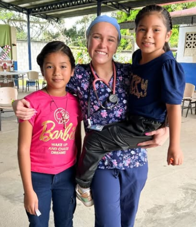 A nurse taking a photo with two children