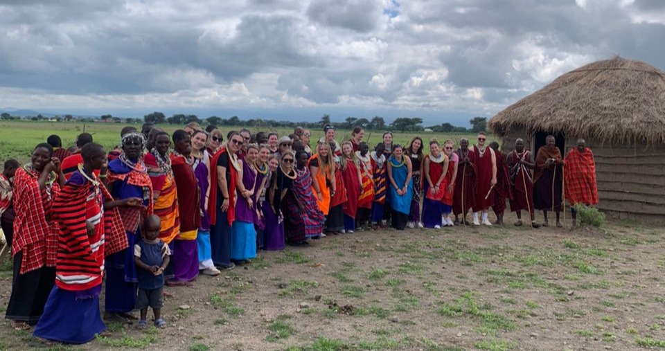 A group of villagers and volunteers taking a photo together