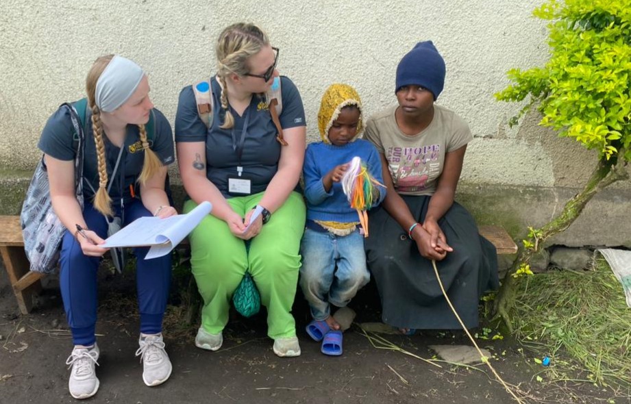 Two nurse volunteers helping a mother her child